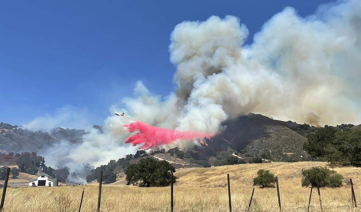 An air tanker drops retardant on the Camino Fire as it burns in the hills near Huasna on Tuesday, June 28, 2022.