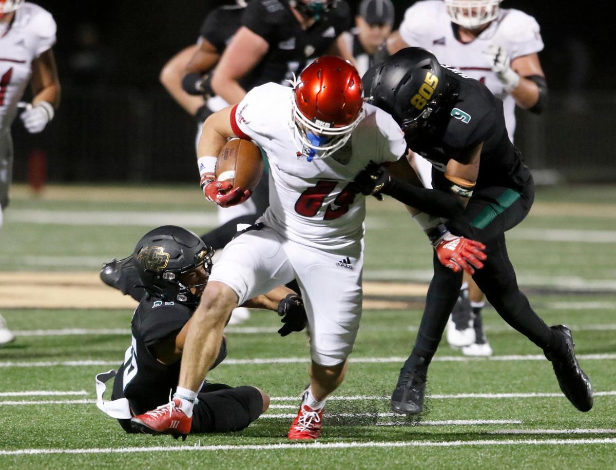 Cal Poly defenders Brian Dukes (9) and Jeremy Justice (25) tackle the Eagles’ Collin Fujimoto-Young (69). Cal Poly lost to Eastern Washington 17-10 in a Big Sky Conference football game at Alex G. Spanos Stadium in San Luis Obispo, Saturday, Oct. 22, 2022.