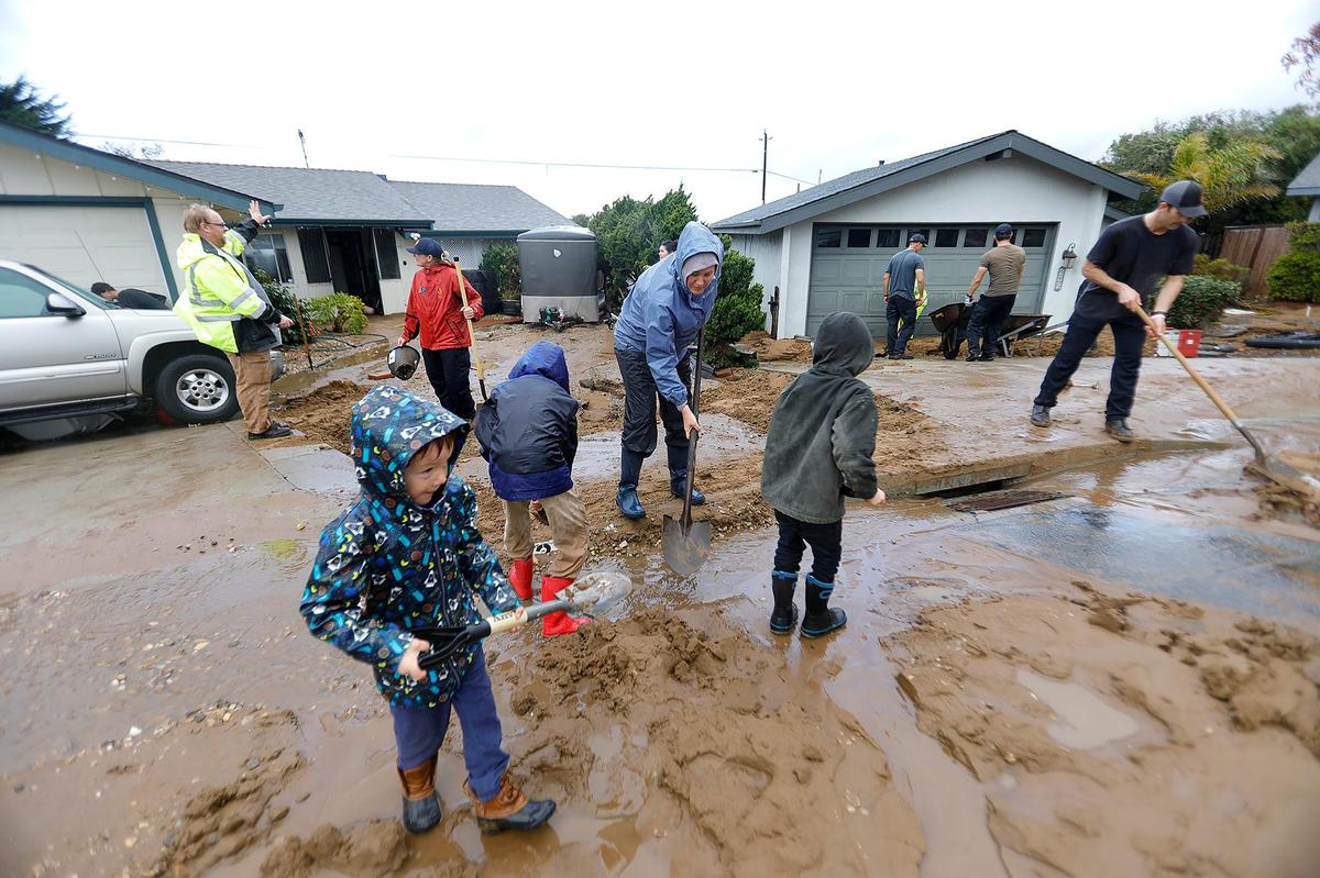 Homes on Vista Court in Los Osos were hit by a torrent of water and mud Monday afternoon, causing devastating damage. Here, Heather Saiki and her kids, who got shovels for Christmas, help with the cleanup effort on Jan. 10, 2023. From left are Cory Saiki, 5, Ruben Saiki, 9, and Everett Saiki, 7.