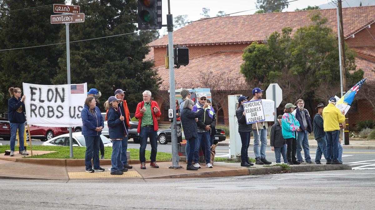 Over 50 protesters gathered near the Veterans Memorial Building in San Luis Obispo with signs in support of veterans services and critical of President Trump and Elon Musk on March 14, 2025.