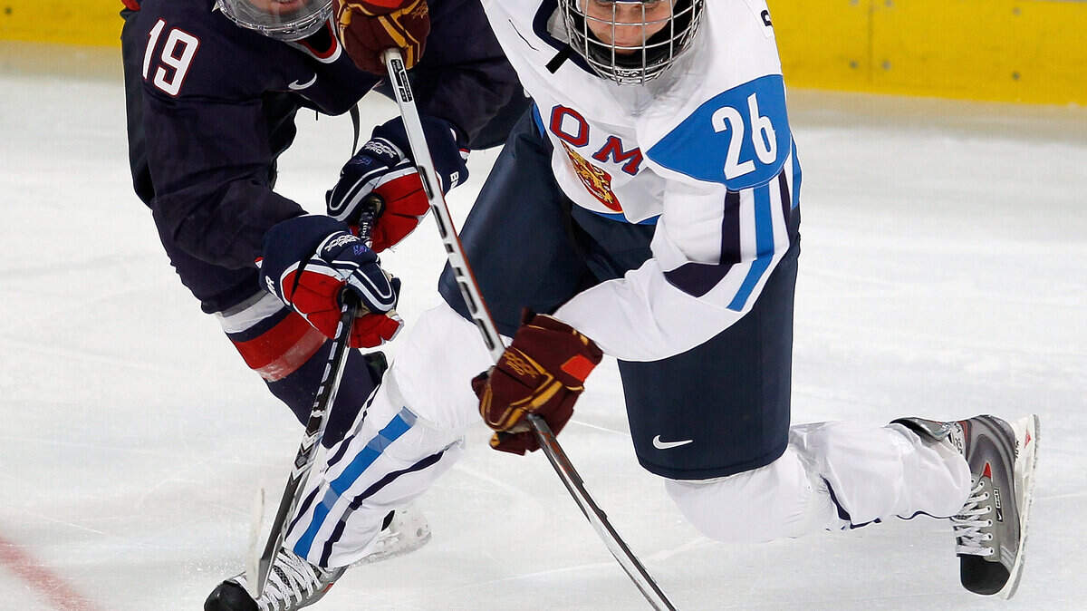 Gigi Marvin of the U.S. (19) and Finland's Heidi Pelttari (26) battle for the puck. (Harry E. Walker / MCT)