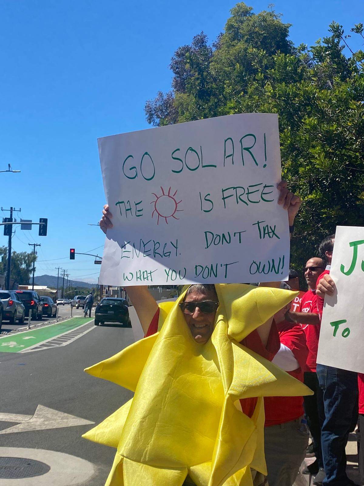 “Don’t tax the sun” protestors facing cars passing on Higuera Street, outside the SLO PG&E offices on Tuesday, July 26.
