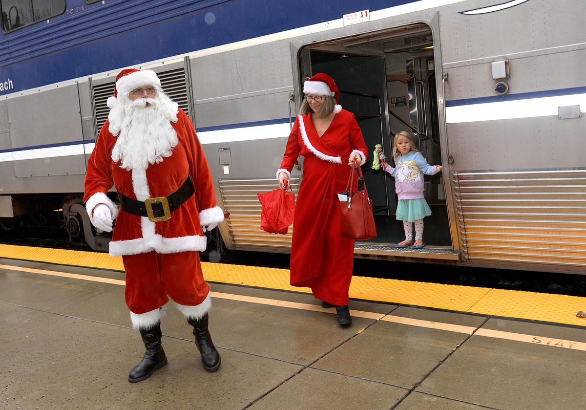 Mr. and Mrs. Santa Claus, aka Paul and Dorothy Deis of Cambria, paid a visit to San Luis Obispo on Saturday, arriving by rail on the Amtrak Surfliner No. 763. A pouring rain stopped just in the nick of time. Santa was then shuttled over to the San Luis Obispo Railroad Museum to meet with children and take photos. Paul Deis, a member of the San Luis Obispo Railroad Museum, has performed as Santa every year for free.