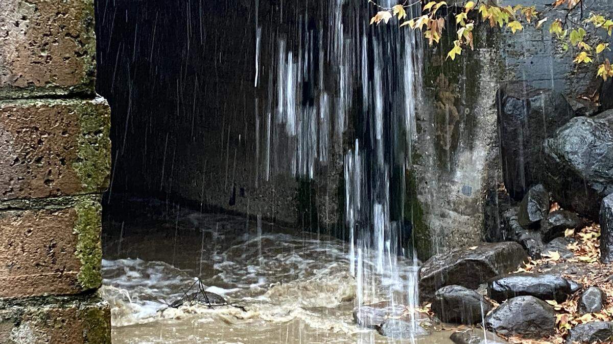Water from an overflowing roof gutter into San Luis Creek during a storm on Feb. 16, 2026.