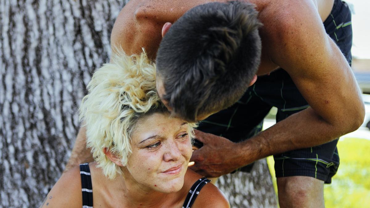 Makaila Currell gets a kiss from her fiance, Carey Vasquez, in the shade of a tree at the Sunken Gardens park in Atascadero during a hot afternoon in 2018.