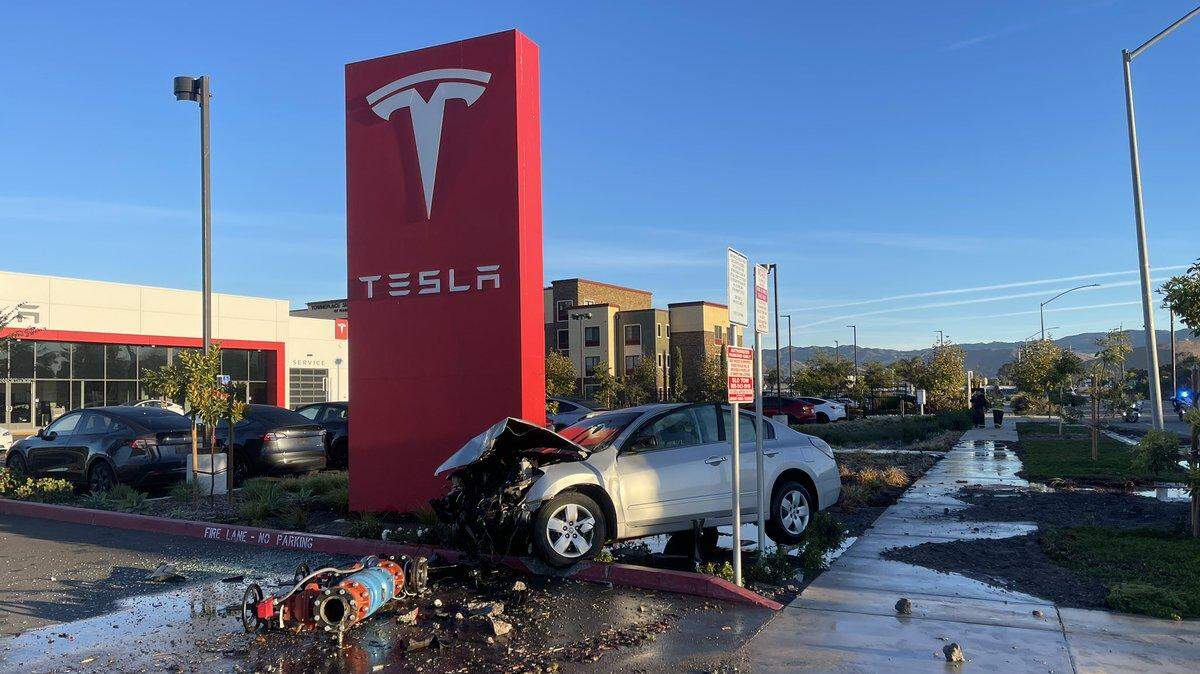 A gray sedan veered of of Highway 101 and across Calle Joaquin, where it collided with the sign and a water valve at the Tesla dealership on Wednesday, Nov. 13, 2024.