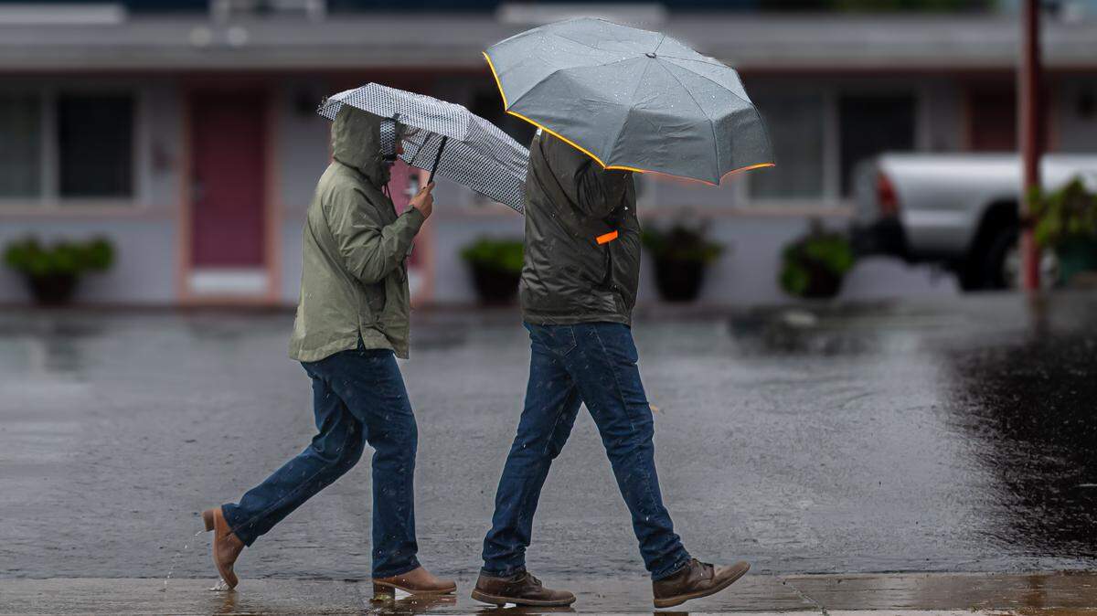 People walk around Morro Bay in the rain on Jan. 4, 2026.