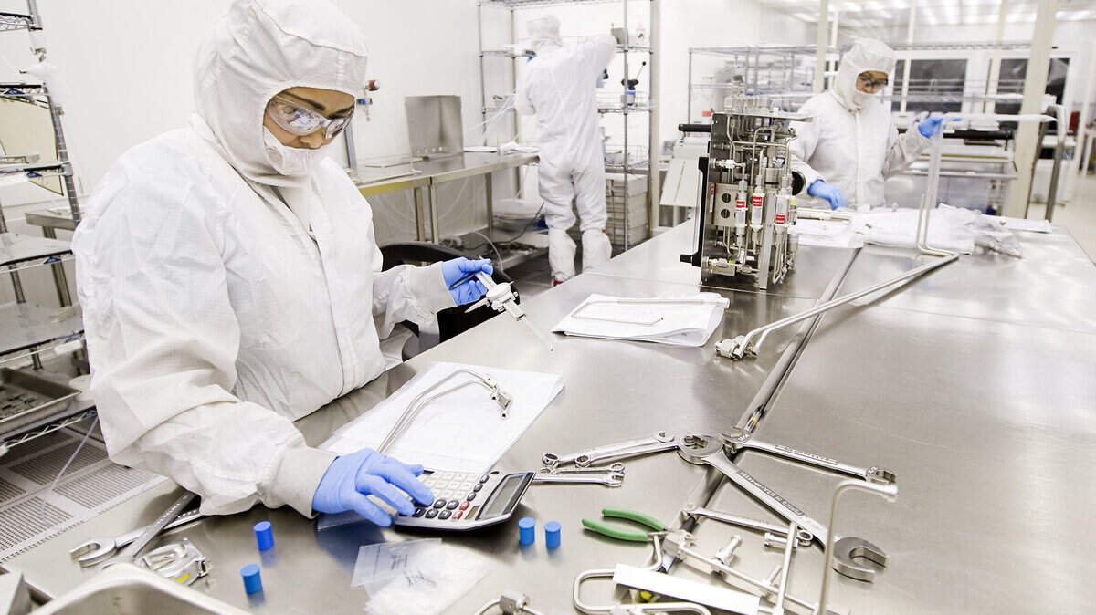 Workers assemble parts for a semiconductor manufacturing tool inside a clean room at SAES Pure Gas in San Luis Obispo.
