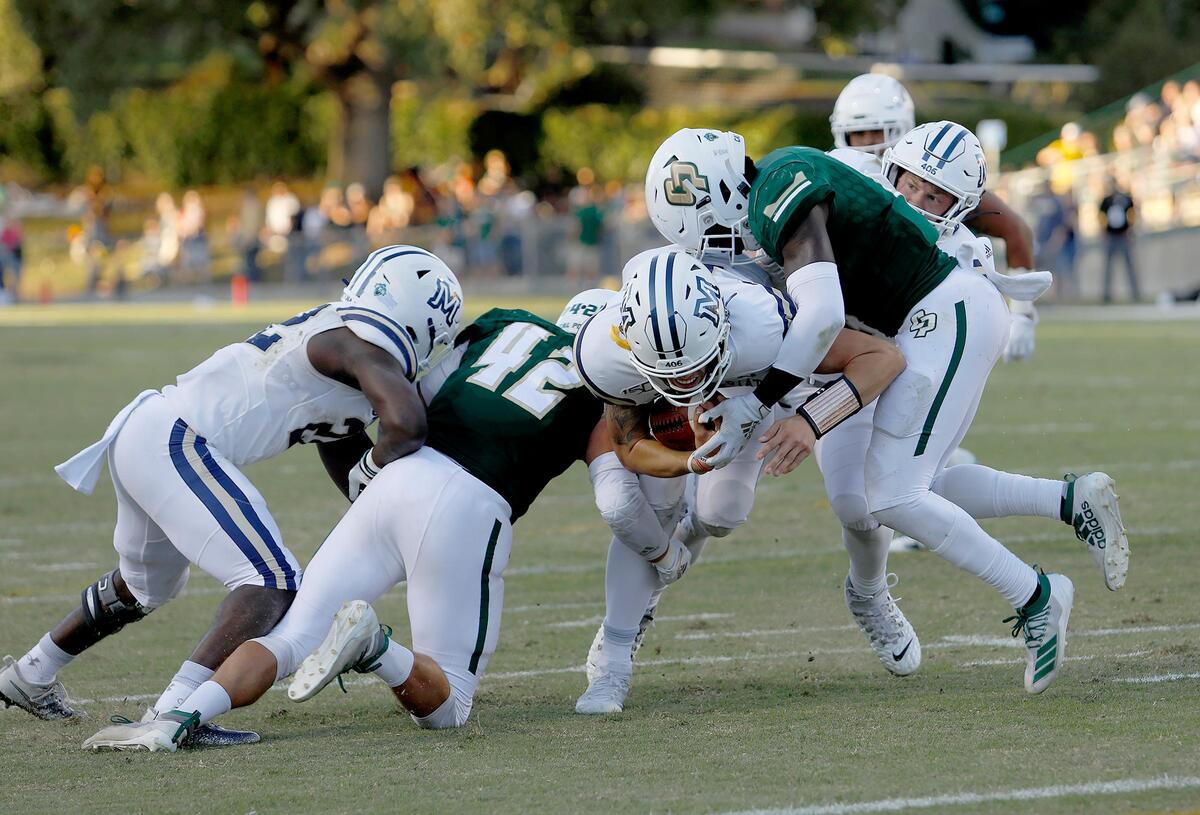 Cal Poly defenders Matt Shotwell (42) and Kitu Humphrey (8) tackle Montana State’s quarterback Tucker Rovig on Saturday at Alex G. Spanos Stadium.