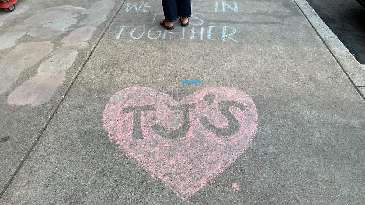 Trader Joe’s wrote messages to its customers in chalk on the sidewalk to mark its socially distanced line outside the San Luis Obispo store during the COVID-19 pandemic in April 2020.