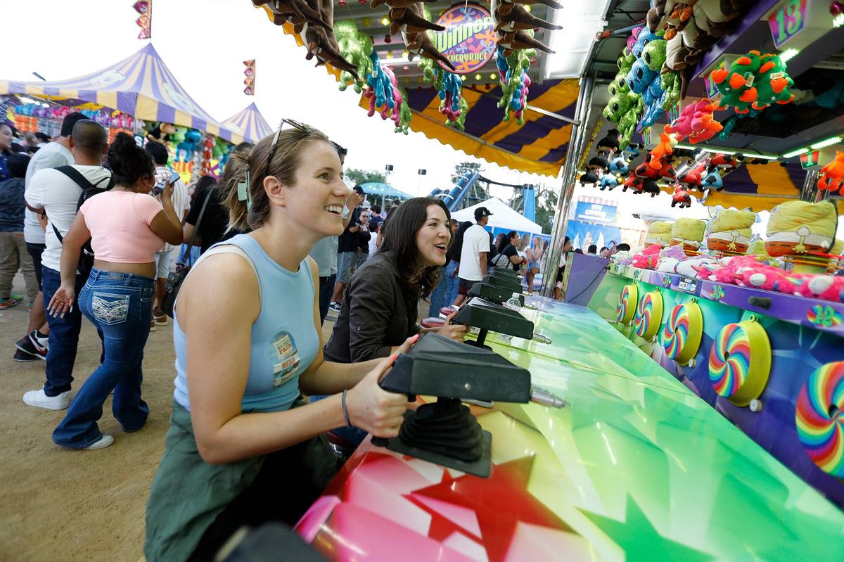 Tribune reporters Kelsey Oliver, left, and Chloe Shrager battle for prizes in a squirt gun game at the Mid-State Fair on Wednesday, July 17, 2024.