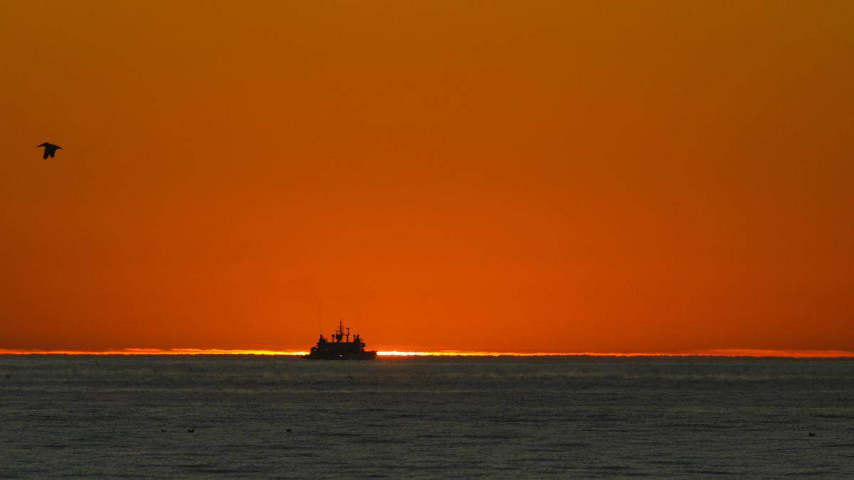 The René Descartes, a cable installation ship, is on the horizon as the sun sets off the coast of Pismo Beach on Monday, Nov. 16, 2020.