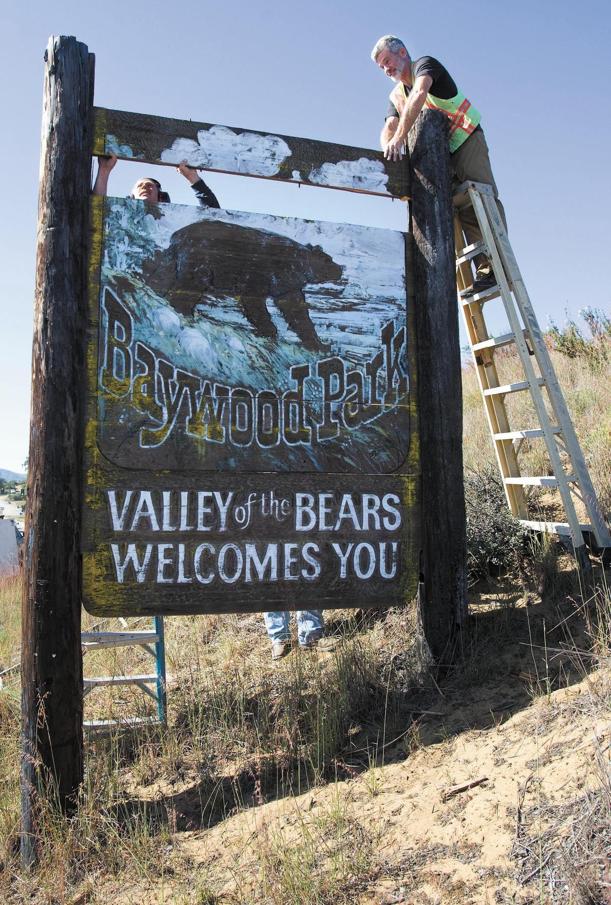 Gerard Ages, left and Bob Crizer remove panels of a 1979-era sign in Los Osos that undwent restoration in April 2013.