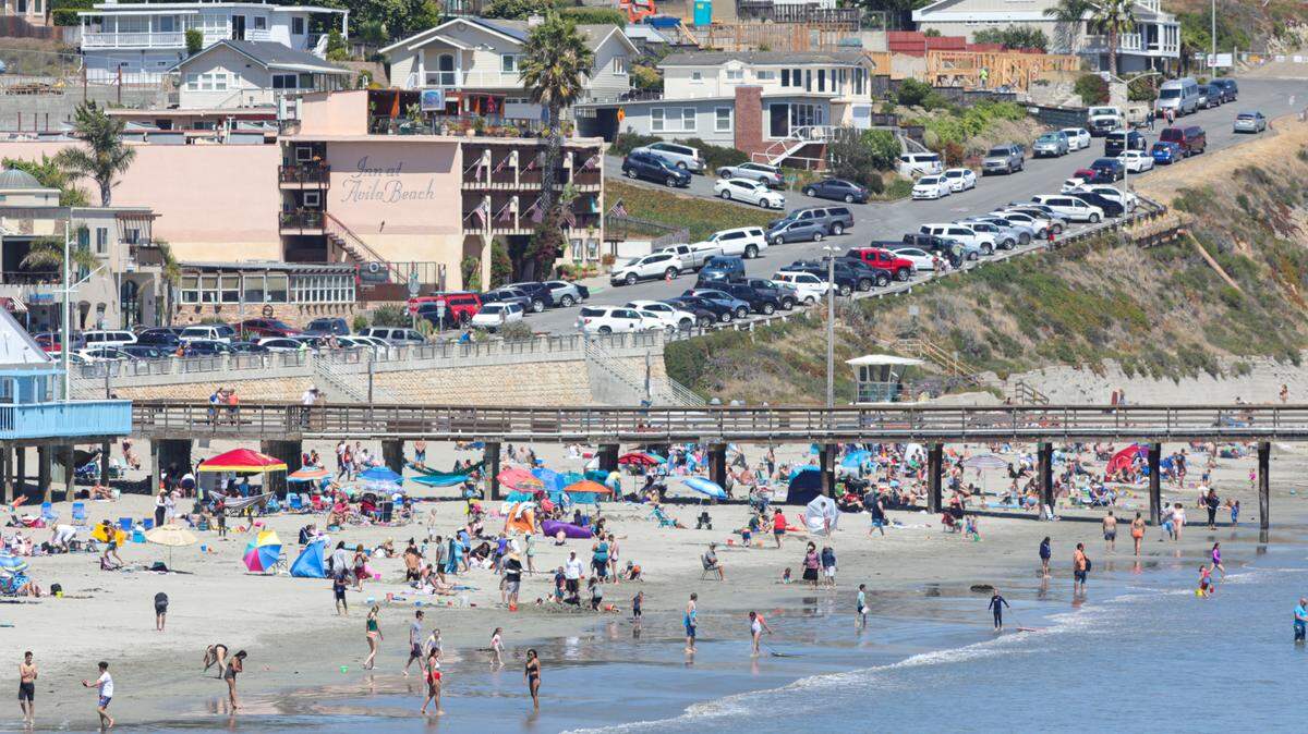 Beachgoers enjoy Avila Beach over the Fourth of July weekend. Locals have worried that large numbers of visitors spread coronavirus, but health officials have linked more outbreaks to bar hopping and graduation parties.