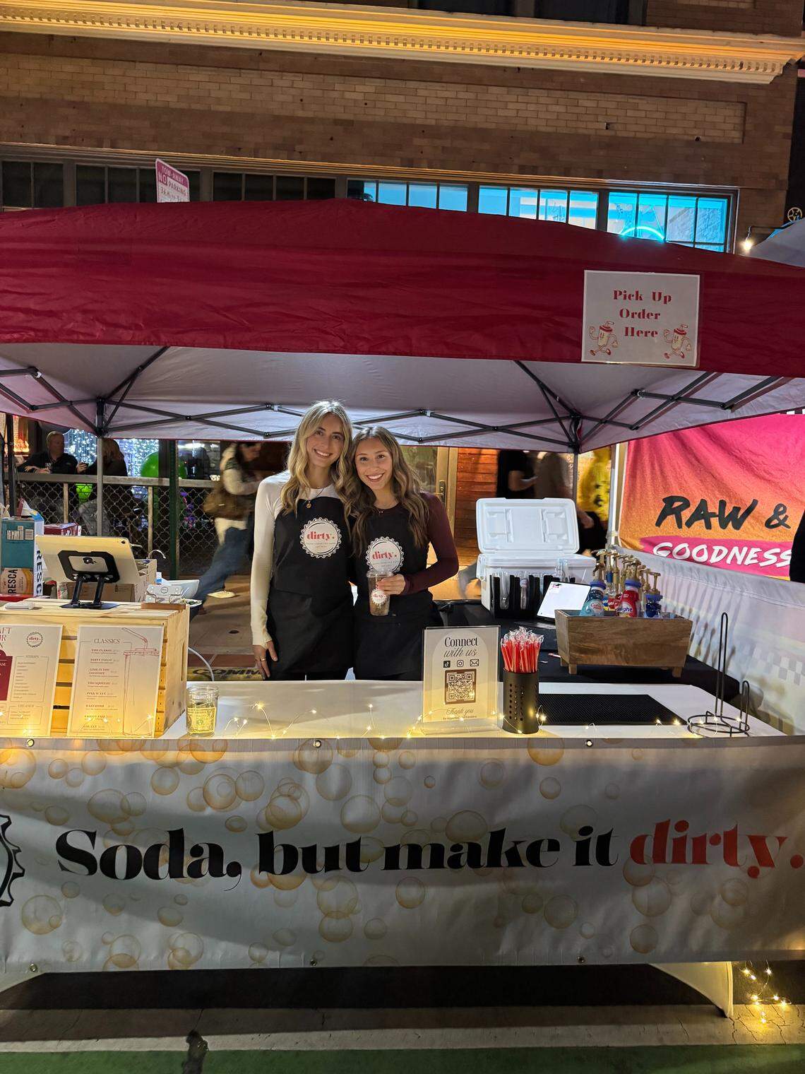 Cal Poly students Delainee Fernandes, left, and Madison Andrade launched a dirty soda business in November 2025. The company sells sodas mixed with syrups and cream every Thursday at the Downtown SLO Farmers Market.
