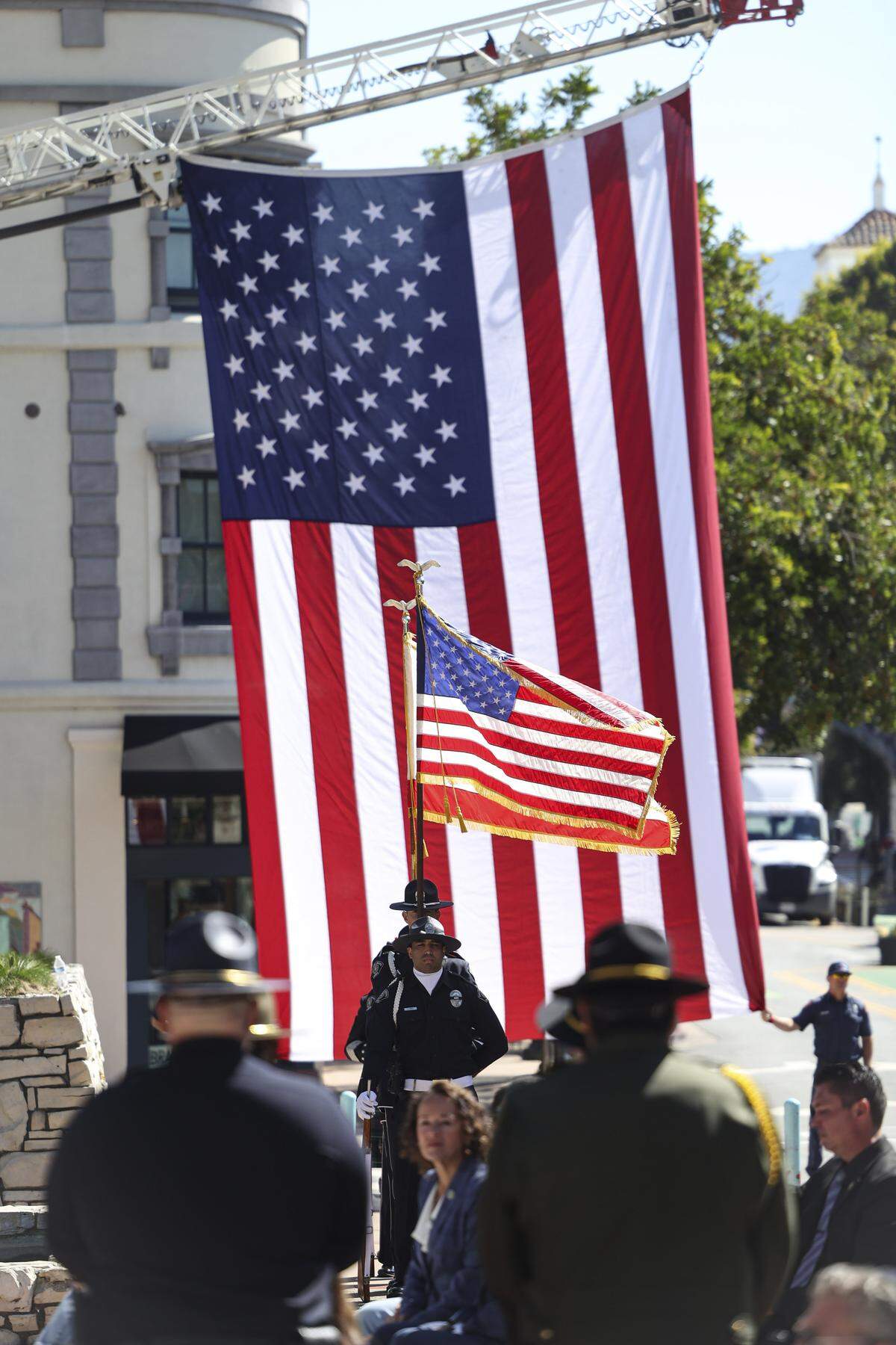 Color guard stands in front of flag hanging from Engine 1 of San Luis Obispo City Fire. The county's annual Peace Officers' Memorial ceremony was held this year at San Luis Obispo's Mission Plaza May 7, 2026.