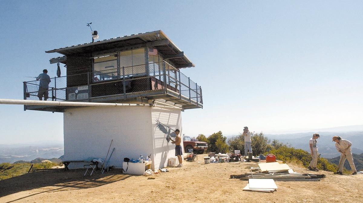 The lookout has spectacular views from its 3180 foot elevation in the Santa Lucia range. It is over 6 miles of dirt road south of Pozo so visitors are advised to check the website www.condorlookout.org Anthony Prieto paints a life size condor mural on the side of the former fire lookout Oct. 6, 2002.