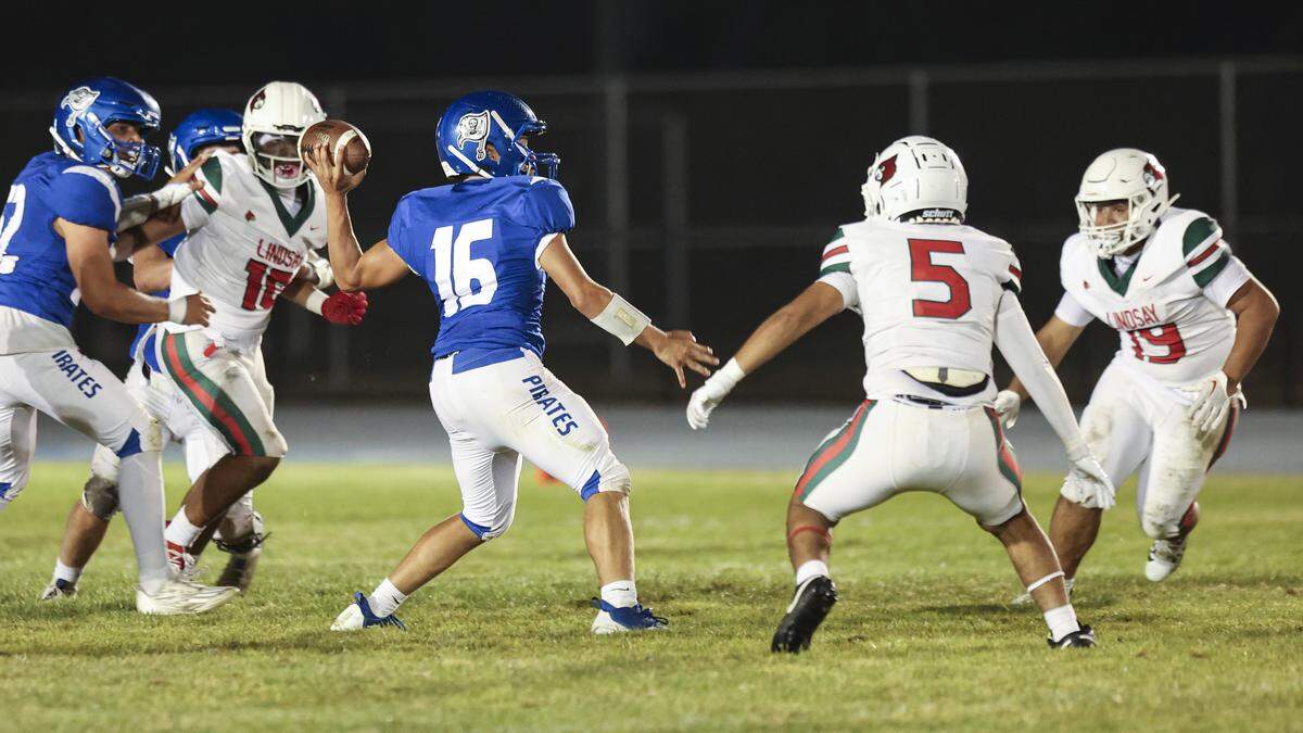 Sands Dougherty throws under pressure from the Lindsay pass rush. Morro Bay beat Lindsay 52-24 on Aug. 29, 2025, in a high school football game.