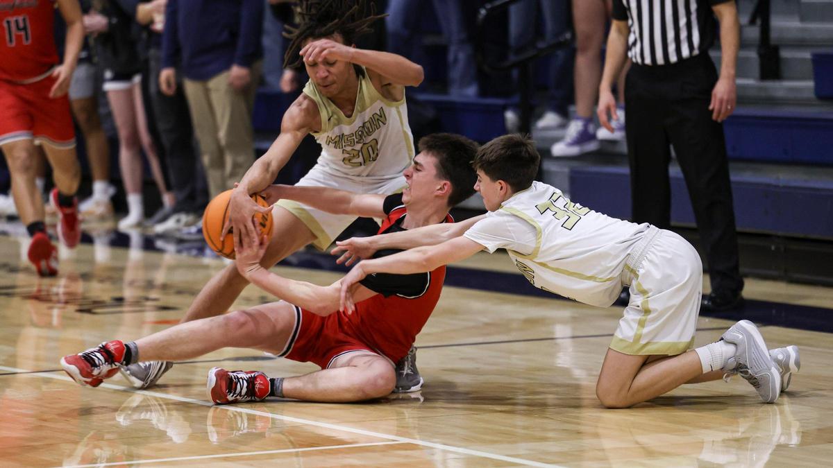 Jayden Nozil left and Brody Miller swarm Jared Pimentel, of Hanford. Mission Prep won 74-48 over Hanford in a boy’s basketball playoff Feb. 13, 2024.