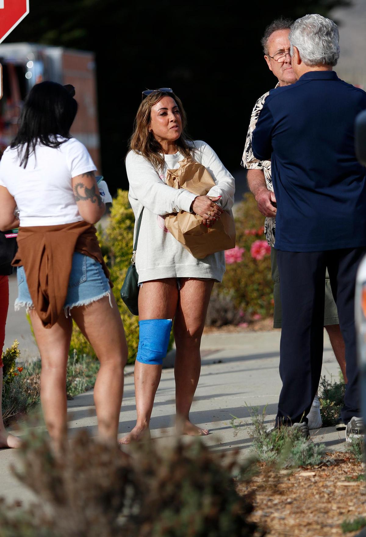 Donald Sandbrook of New Zealand and his two daughters were among the passengers who were burned when a hot, red fluid poured through a Hearst Castle tour bus on Saturday, Oct. 22, 2022. Shareena Sandbrook, center, and her father talk with State Parks personnel about their injuries.