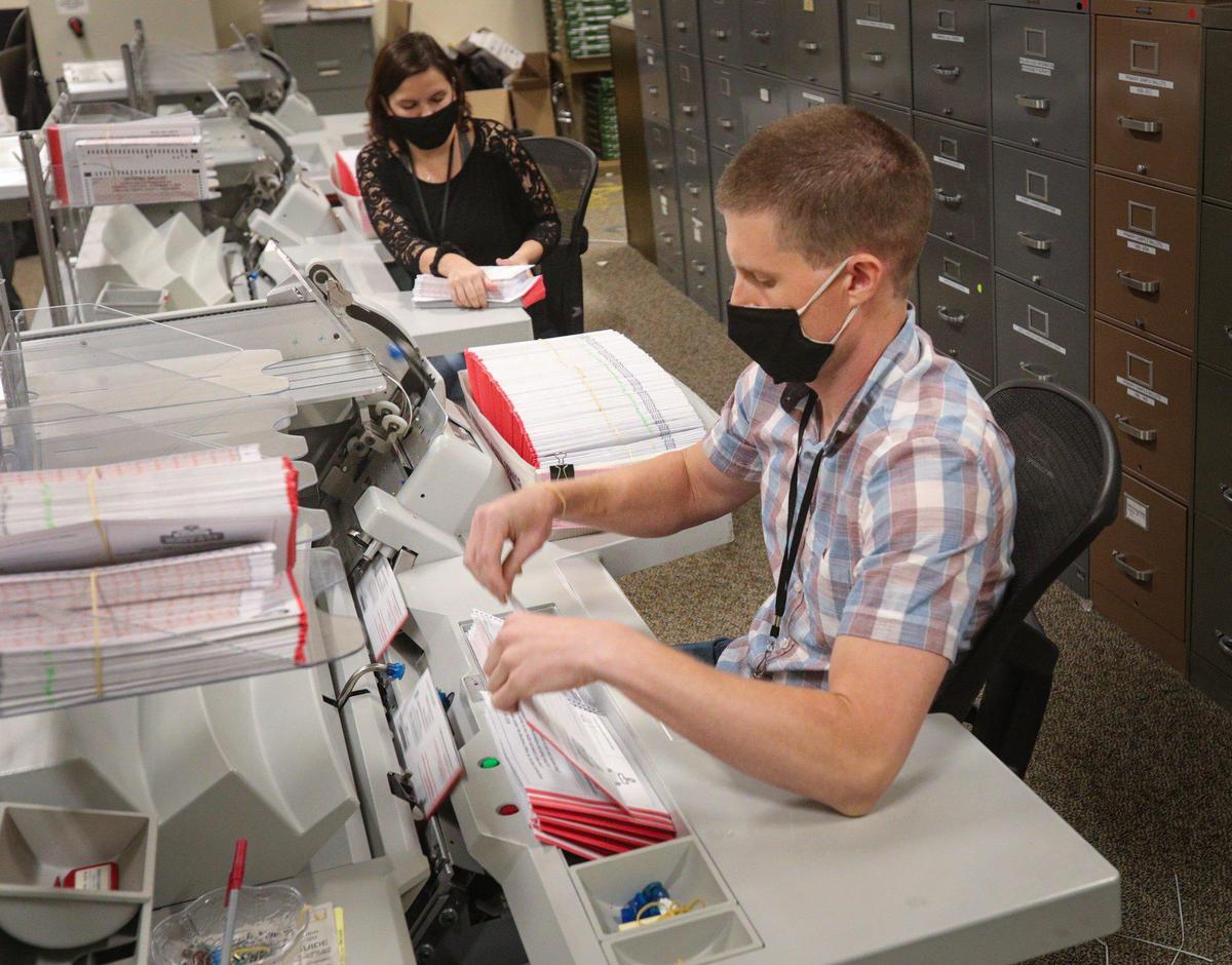 Kiley Keohen, left, and Milan Limbo mechanically open envelopes and remove ballots in bundles of 50. The San Luis Obispo County Clerk Recorder’s Office had already received more than 47,000 ballots back from voters more than two weeks before Election Day.