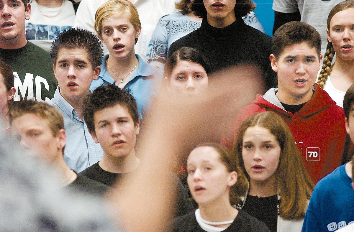 The hand of Gary Lamprecht is a blur as he directs the combined choirs of Morro Bay and San Luis Obispo high schools on Jan. 30, 2003.