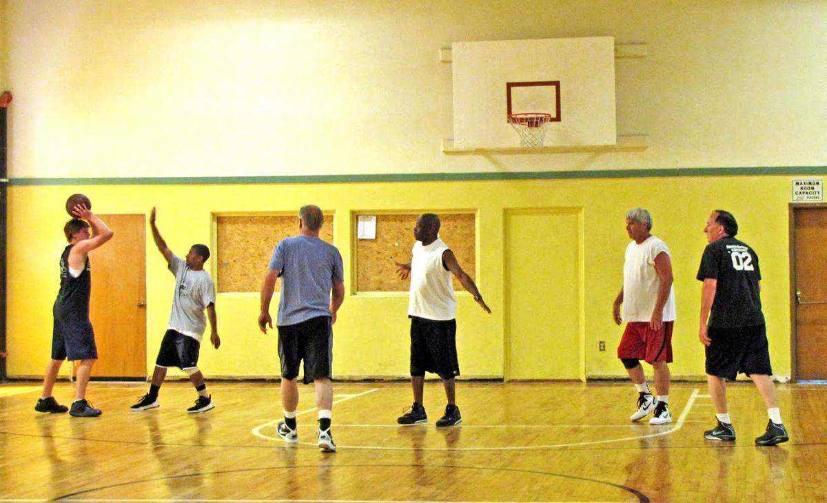 Stan Harris, centercourt, and his basketball “family” play pick-up game at First Presbyterian Church.