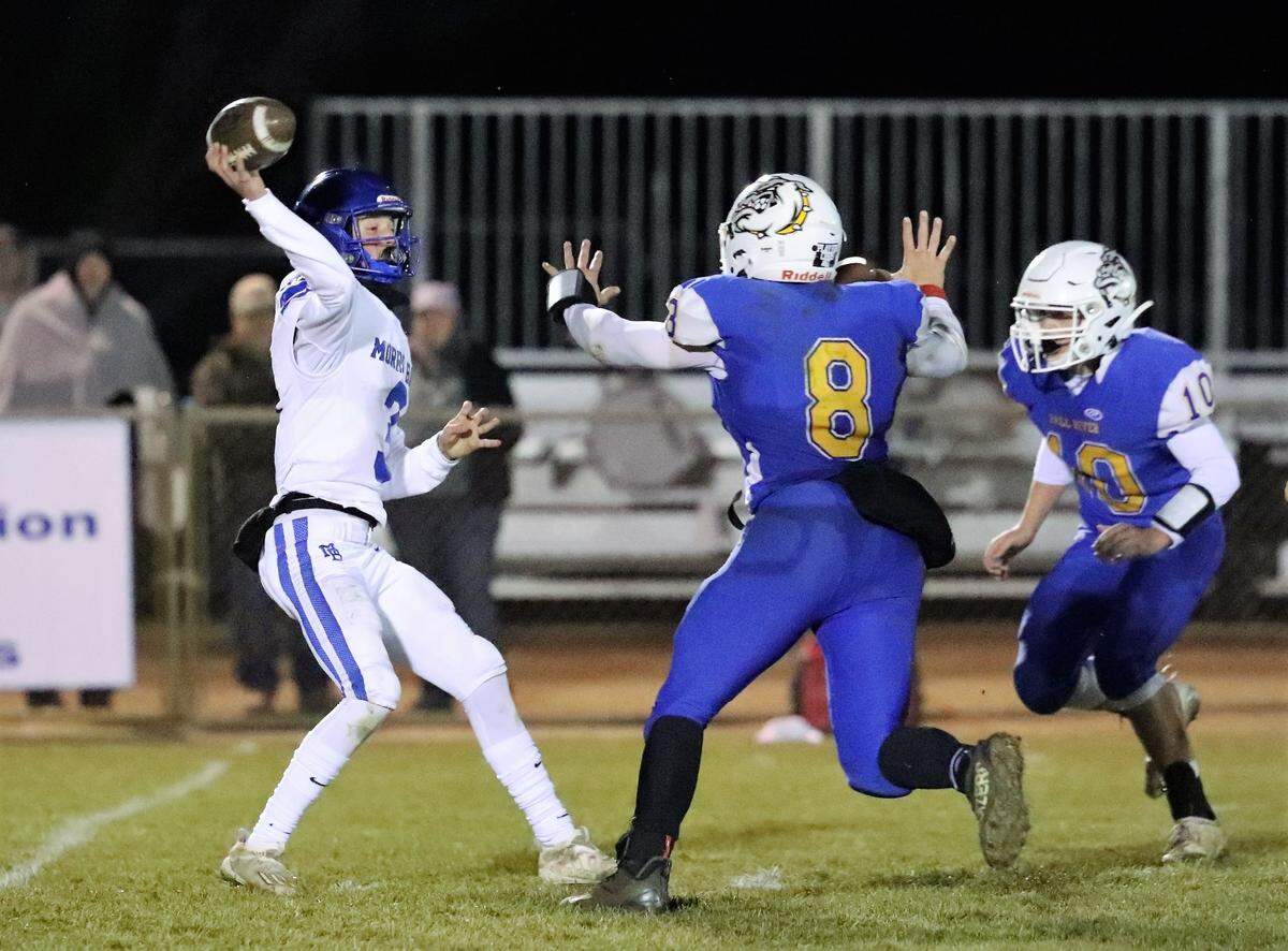 Morro Bay quarterback Nicky Johnson throws a pass under pressure from Fall River’s Ryan Osborne (8) in the Division 7-AA state championship at Fall River on Saturday, Dec. 11, 2021. Fall River won the state title 43-13.