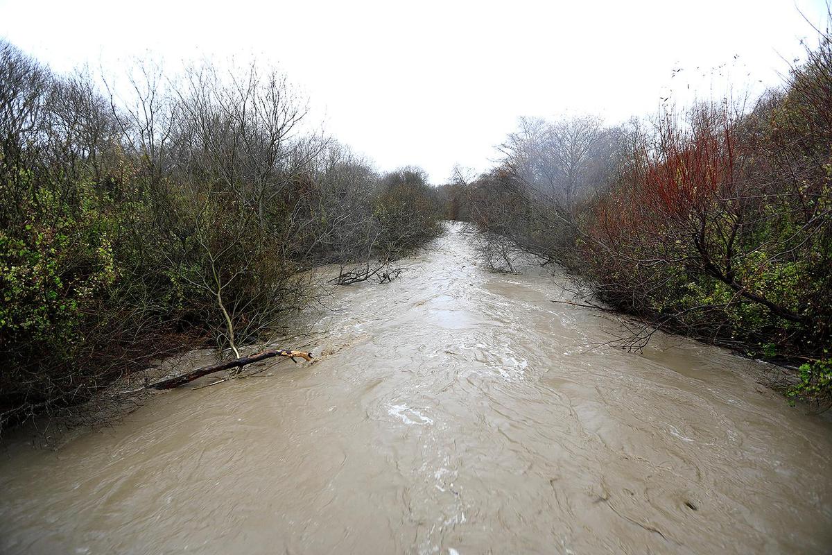 A raging Santa Rosa Creek is filled with floodwaters Thursday as it flows past the Windsor Boulevard bridge to Moonstone Beach in Cambria.