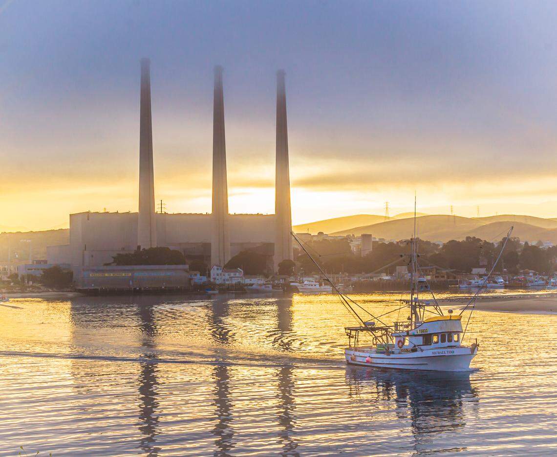 The Morro Bay-based Michael Too heads out to sea on a salmon-fishing trip as the sun rises behind the power plant last week. The salmon catch this year has been the fest local fishermen have seen in 20 years.