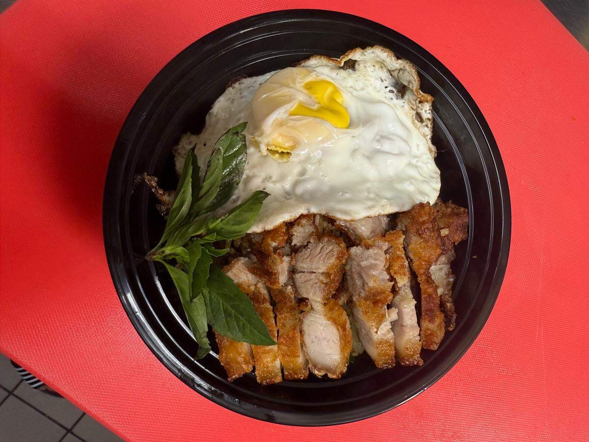 The spicy fried rice pork belly at Thai Easy Bowl in San Luis Obispo. The dish is served with pan fried rice, fried pork belly, a fried egg and fresh basil.