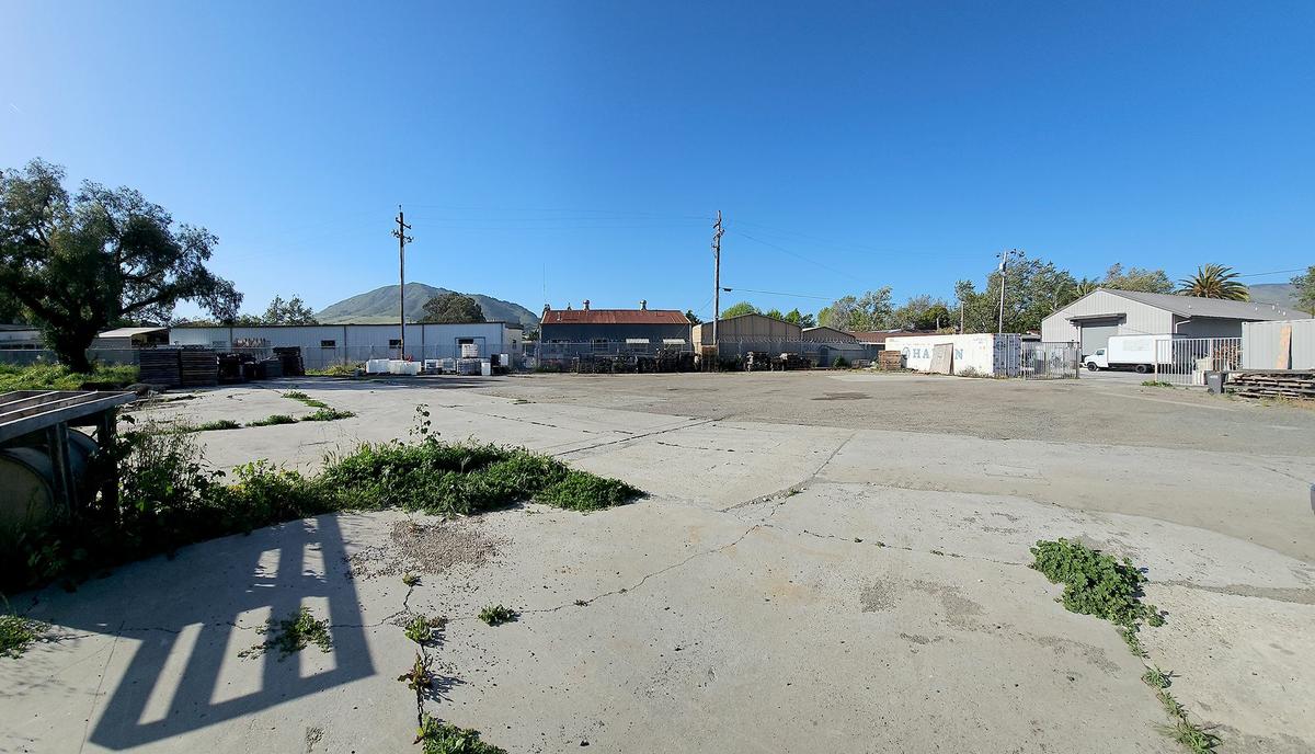 This view is of a field and parking lot behind Black Market Spirits where the new building will be built.