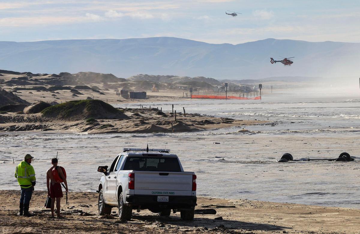 Two of the three rescue helicopters dispatched to the scene fly at Oceano Dunes SVRA. Floodidng resulted as high swells on the ocean combined with seasonal high tides Dec. 28, 2023. A truck that was lost in Arroyo Grande Creek is at right.