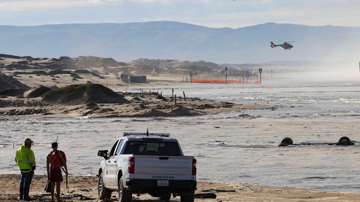 Two of the three rescue helicopters dispatched to the scene fly at Oceano Dunes SVRA. Floodidng resulted as high swells on the ocean combined with seasonal high tides Dec. 28, 2023. A truck that was lost in Arroyo Grande Creek is at right.