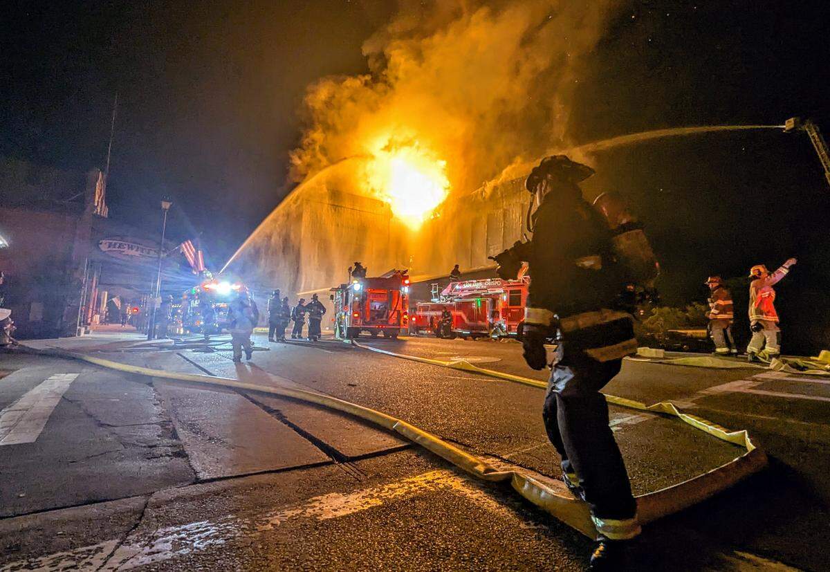 Firefighters spray water on the burning Templeton Feed and Grain building during a nighttime fire in downtown Templeton.