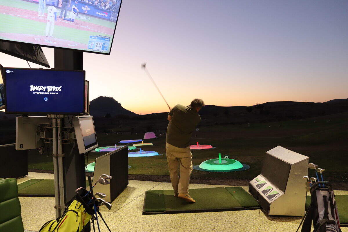 A golfer tries out Swingtime — a Top Golf-style driving range at Dairy Creek Golf Course.