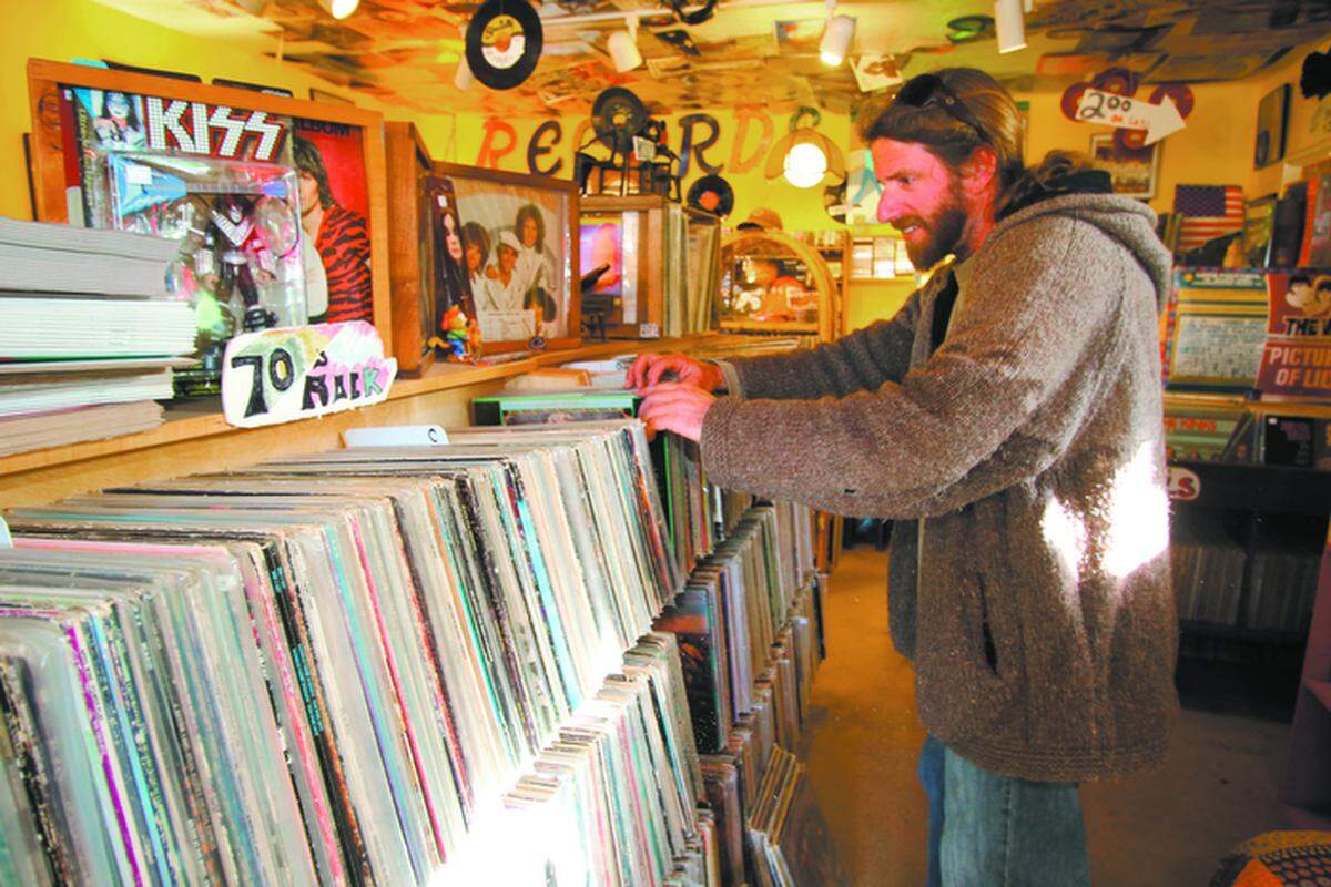 Jeremiah Highhouse, owner of Vinyl Isle in Morro Bay, flips through records at his store.