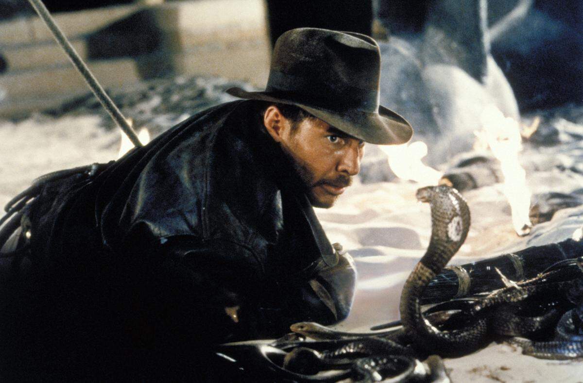 In this undated promotional photo provided by Paramount Pictures, actor Harrison Ford comes face-to-face with a cobra in a scene from “Raiders of the Lost Ark.” Lawrence Kasdan, who wrote the screenplay for the movie, will be honored at the 2020 San Luis Obispo International Film Festival.