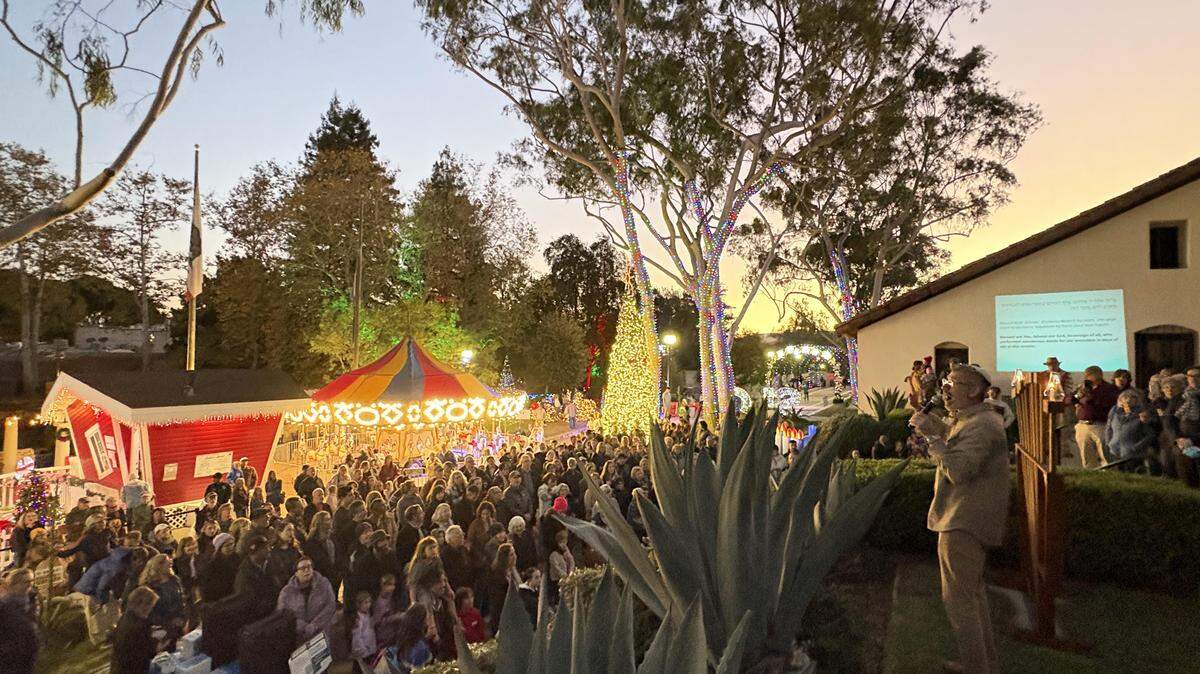 After a moment of silence for the victims of Bondi Beach shooting, Congregation Beth David’s Rabbi Micah Hyman lights the community menorah on the first night of Hanukkah at annual celebration in downtown San Luis Obispo.