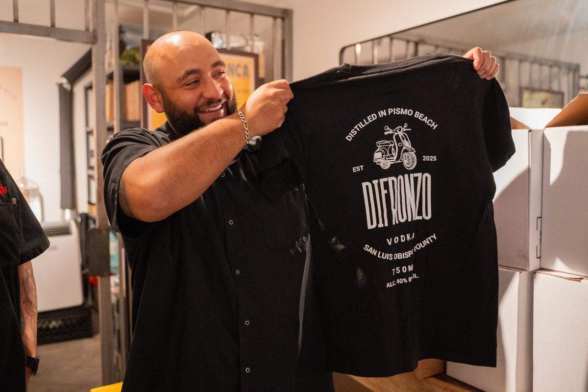Giuseppe’s Italian American Club manager Aurash Afshar shows off merchandise for the restaurant’s new homemade limoncello on Tuesday, May 19, 2026. The deli and restaurant expansion of the existing Giuseppe’s Cucina Italiana in Pismo Beach recently started its own offshoot brand of limoncello in-house.