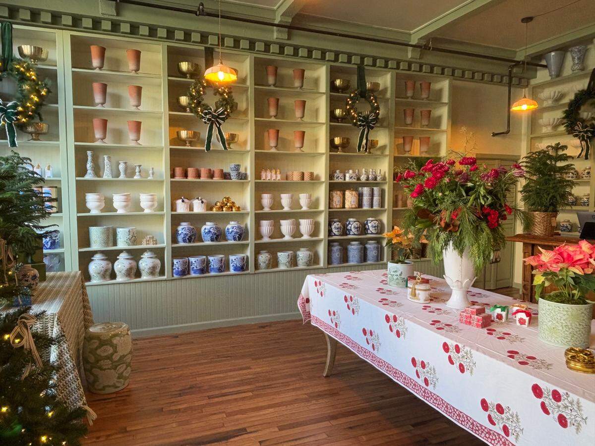 The flower shop is decorated with holiday decorations including pine trees and wreaths.