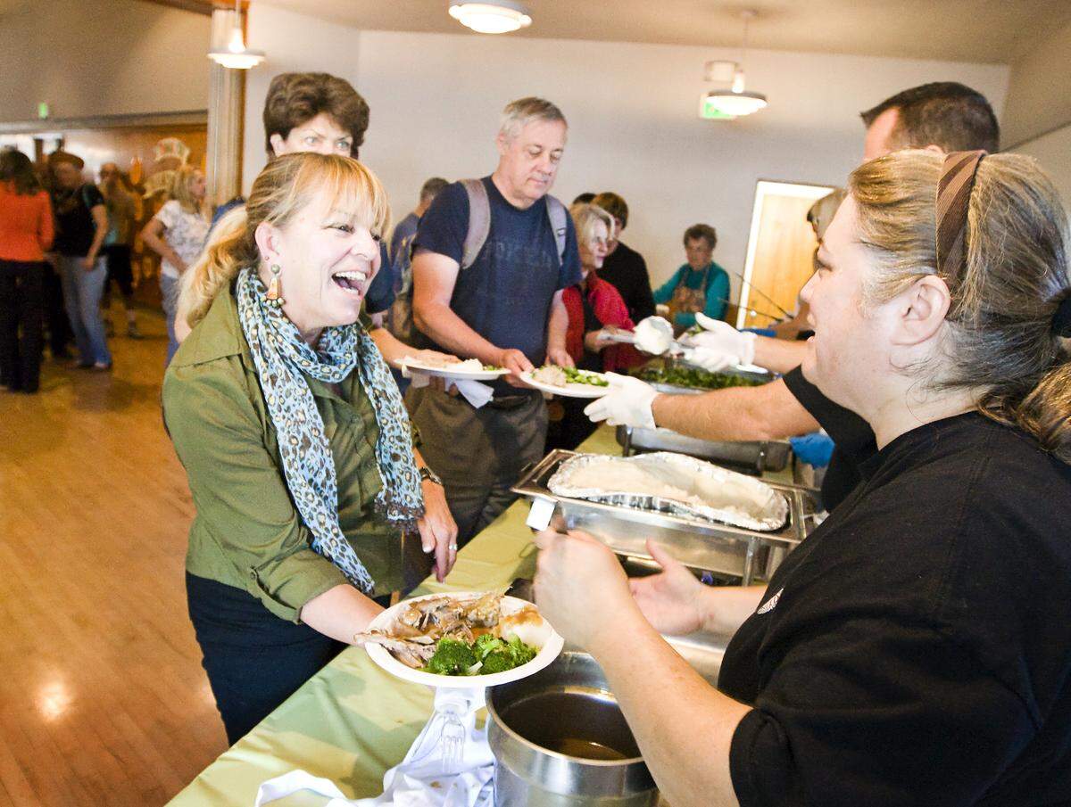 Donna Kube, left, of Morro Bay, gets some gravy from community services officer Rachelle LaPan during the Pismo Beach Police Officers Association’s Thanksgiving Dinner in 2014.