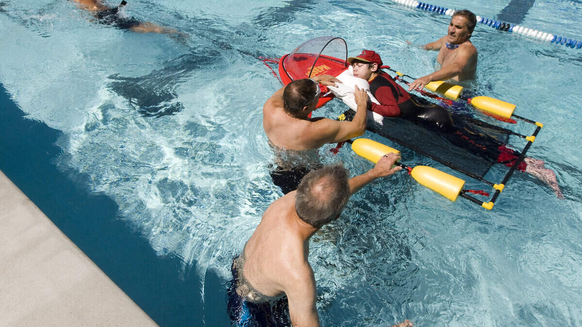 Three Cal Poly students created a device, called an Aquabullet, to help 20-year-old Joseph Cornelius, center, compete in the San Luis Obispo Triathlon. Joseph Cornelius has cerebral palsy; his father, John, on his left, will be helping Joseph complete the race.
