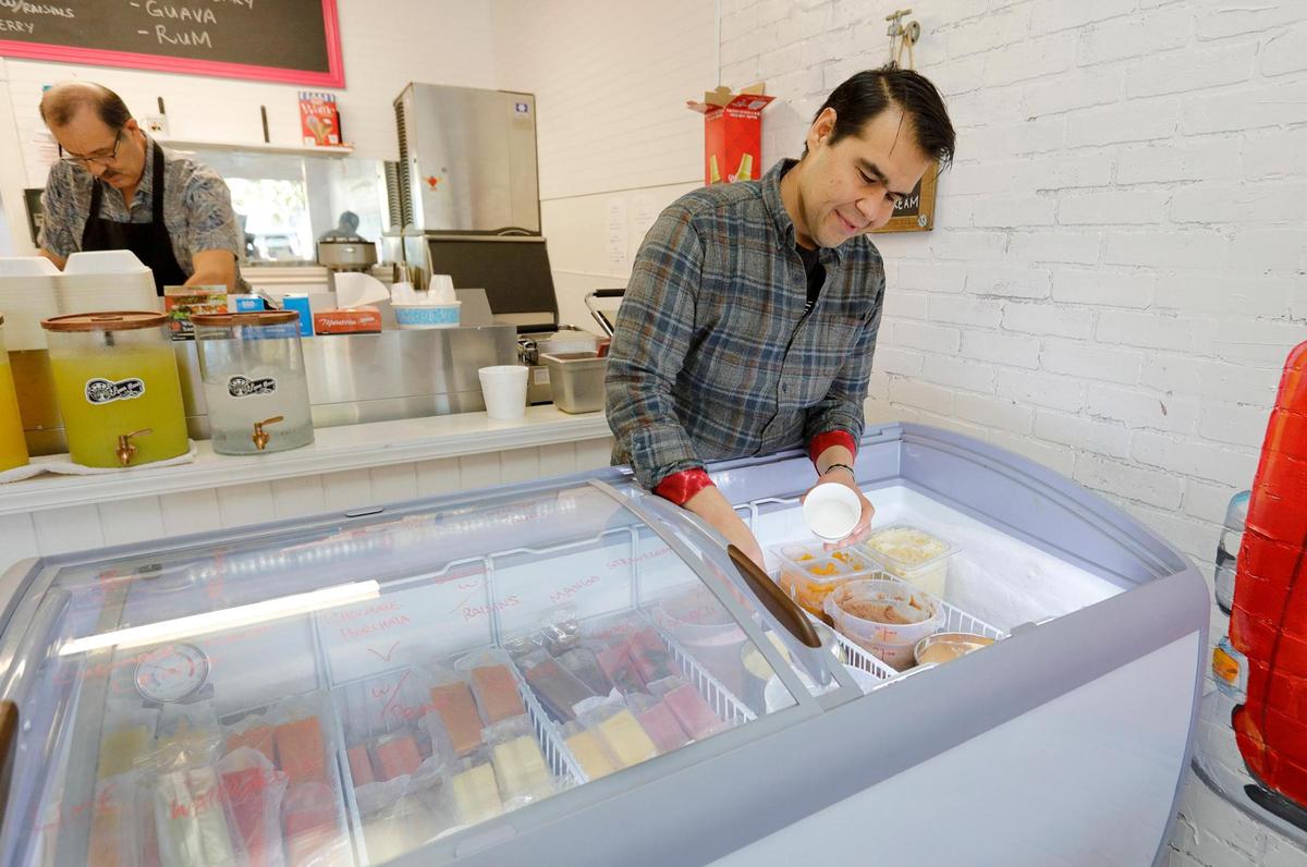 Gil Ruiz, Jr., scoops an ice cream cup at Luna Llena Deli in Morro Bay. He and his father, Gil Ruiz, Sr., opened the restaurant at 859 Main St. in October 2022.