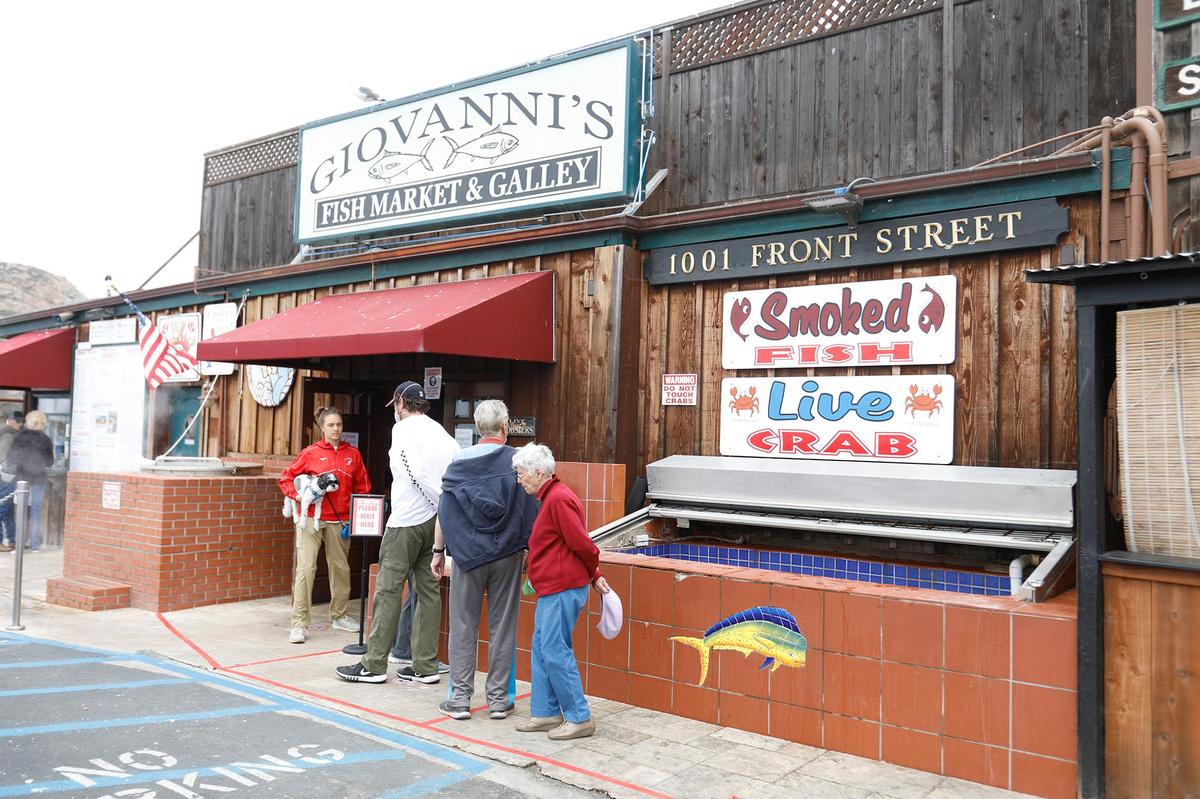 Customers wait in line at Giovanni’s Fish Market in Morro Bay. Police on Saturday arrested three suspects accused of stealing a tip jar from the restaurant.