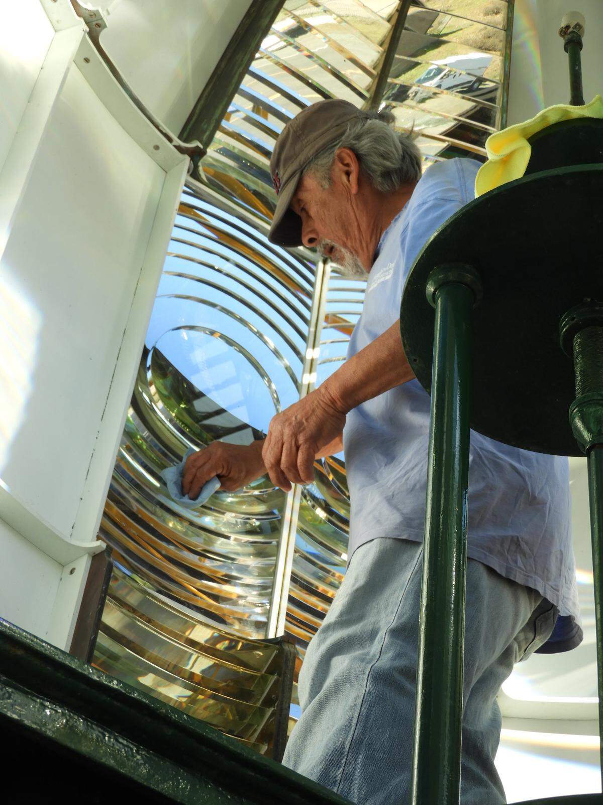 Abel Martinez cleans the inside of the Piedras Blancas Lighthouse lens in 2018.
