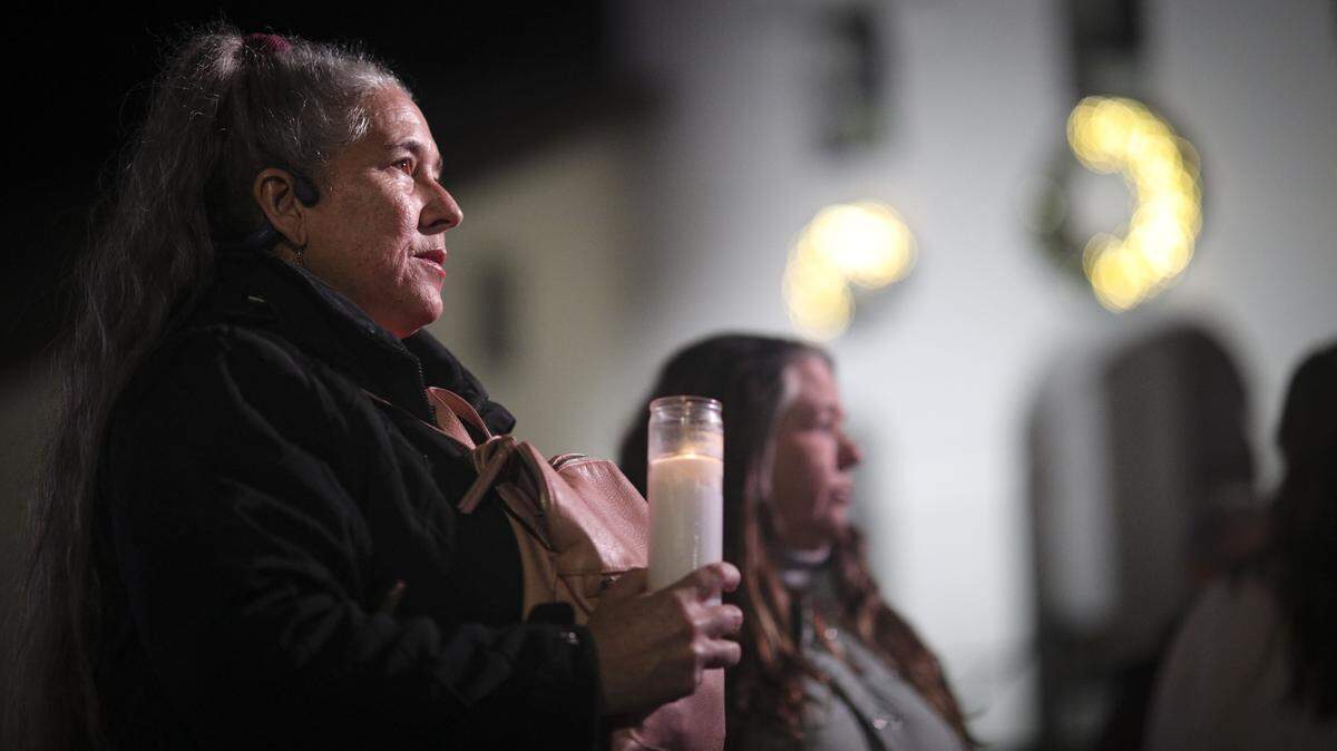 Kristen Sanchez, left, and Cecilia Boudreau held candles at a vigil at Mission Place on Jan. 8, 2026. About 200 people gathered to honor Renee Nicole Good, the Minneapolis woman killed by ICE, and to protest recent ICE activity on the Central Coast.