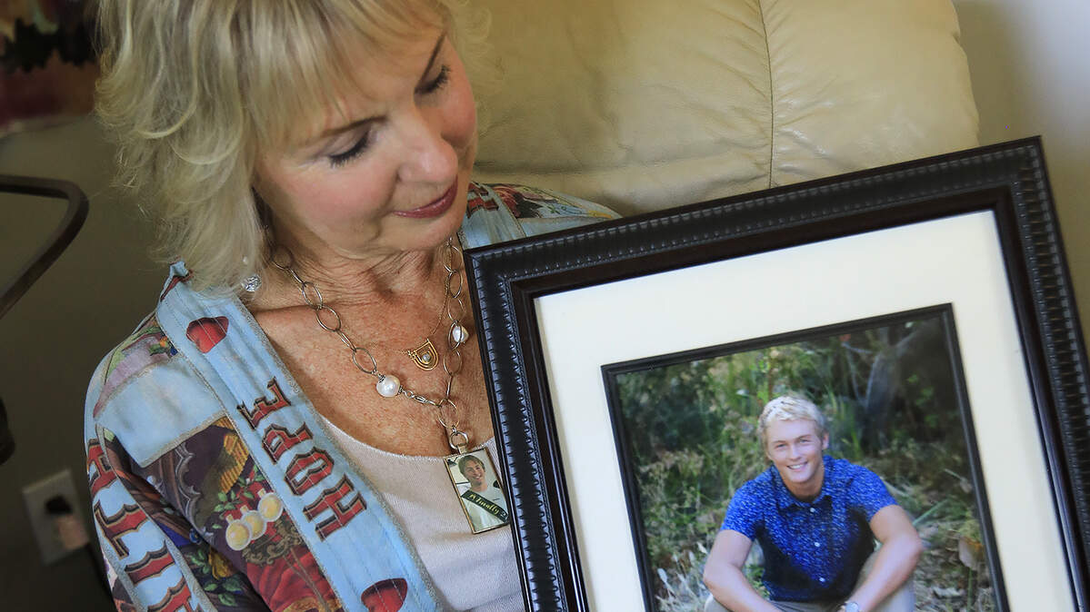 Lauri Strain, posing with a photo of her son, has started a nonprofit, HOPE With IAN, to spread awareness and education about suicide and mental health. Strain’s son Ian died by suicide after being diagnosed with cannabis-induced psychosis and bipolar I.