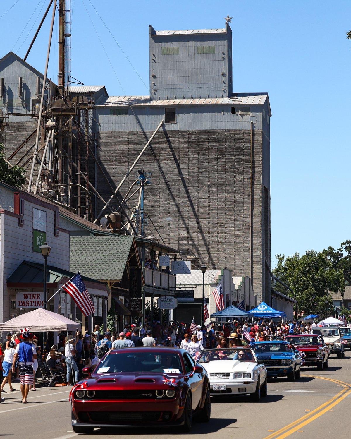 Red, white and blue classic cars roll past Templeton Feed and Grain during the Templeton 4th of July Parade on Tuesday, July 4, 2023.