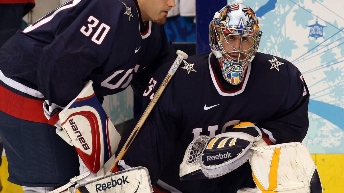 Tim Thomas of the United States (30) talks to goalie Ryan Miller (39) after an overtime loss to Canada. (George Bridges/MCT)